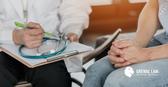 Doctor's hands holding a clipboard and a female patient's hands folded in her lap.